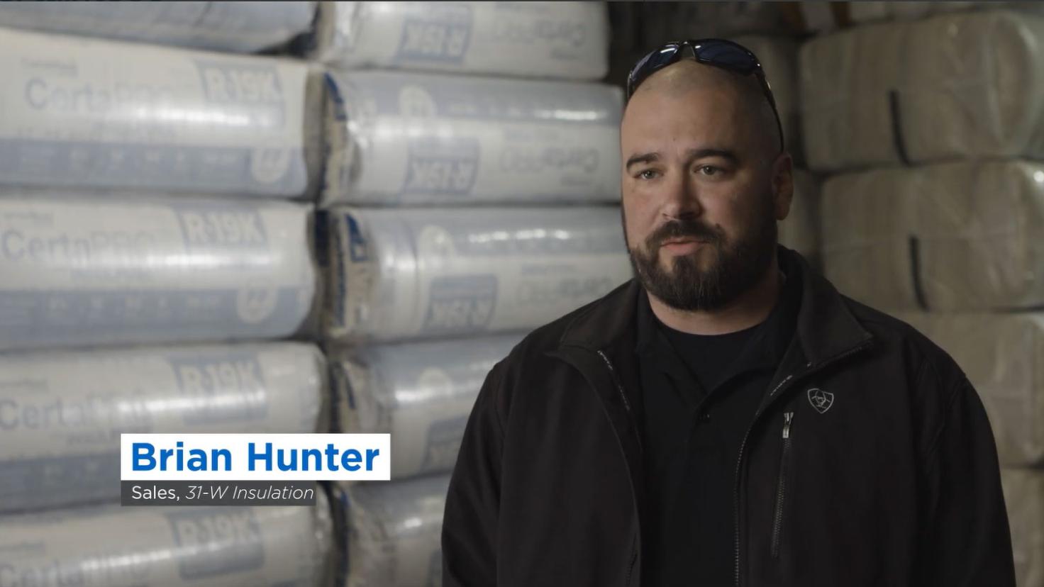 A man in a black tshirt being interviewed